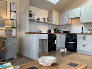 a kitchen with white cabinets and a dog standing in the floor at 1 Bed in Ullswater 94068 in Watermillock +11 photos