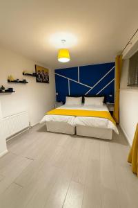 ein Schlafzimmer mit einem großen Bett mit einer blauen Wand in der Unterkunft 3 Bed Home, Sleeps 7 with Garden in Basildon in Basildon