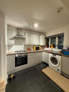 eine Küche mit einer Waschmaschine in der Mitte in der Unterkunft 3 Bed Home, Sleeps 7 with Garden in Basildon in Basildon