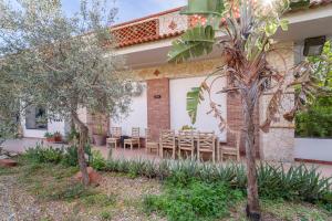 un patio di una casa con sedie e alberi di IL VIVAIO Bed and Breakfast a Santa Teresa di Riva