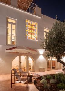 a white building with two chairs and an umbrella at Casa Amarela Health & Spa in Beja