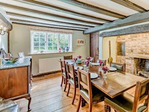 a dining room with a wooden table and a fireplace at 4 Bed in Icklesham BT067 in Icklesham