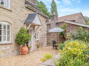 a brick house with an umbrella and a patio at 1 Bed in Newton St Margarets 93134 in Bacton