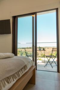 Un dormitorio con una cama y un balcón con vistas. en Nadine sea side villas, en Lárnaca 122 fotos más