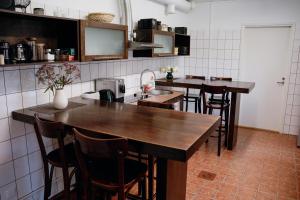 a kitchen with wooden tables and bar stools at Hostel Ingeri in Viljandi