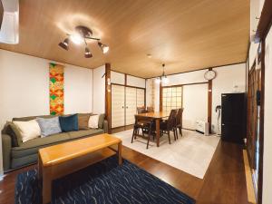 a living room with a couch and a table at 民宿ひだまり Minsyuku Hidamari in Kurashiki