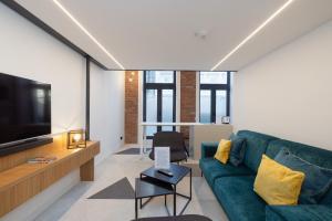 a living room with a green couch and a tv at Fesh Lofts in Vienna