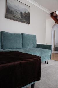 a couch in a living room with a painting on the wall at Luxe Entire 3 Bed Home - LHR 15 mins - London City 35 mins in Denham