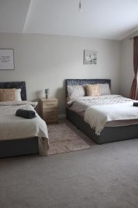 ein Schlafzimmer mit zwei Betten und einem Teppich in der Unterkunft Luxe Entire 3 Bed Home - LHR 15 mins - London City 35 mins in Denham
