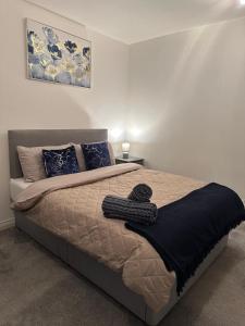 a bedroom with a bed with a black blanket on it at Luxe Entire 3 Bed Home - LHR 15 mins - London City 35 mins in Denham