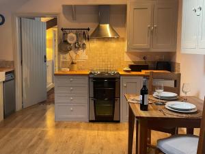 a kitchen with a stove and a table with wine glasses at 1 Bed in Ullswater 94066 in Watermillock +9 photos