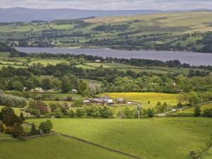 an aerial view of a green field with a lake at 1 Bed in Ullswater 94066 in Watermillock