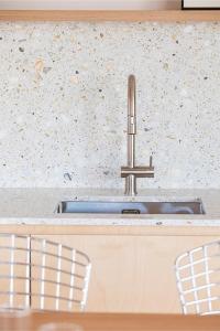 a kitchen counter with a sink and two chairs at Villa Txori Habia - House with ocean view in Guéthary