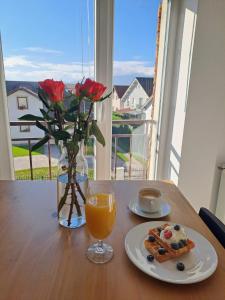 ein Tisch mit einem Teller Essen und einem Glas Orangensaft in der Unterkunft Nordic View Residence in Şelimbăr