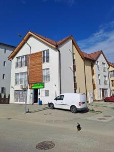 ein weißes Auto, das vor einem Gebäude geparkt ist in der Unterkunft Nordic View Residence in Şelimbăr