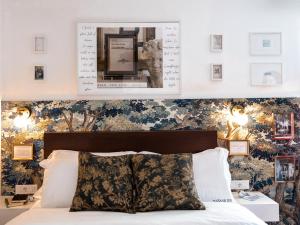 a bedroom with a bed with a floral wallpaper at Bazaar Inn Hotel in Tirana