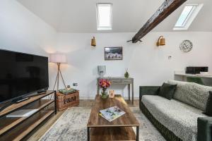 a living room with a couch and a tv at The Cow Shed in Groombridge