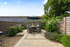 a small garden with a table and an umbrella at The Cow Shed in Groombridge