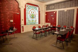 モンペリエにあるGrand Hôtel du Midi Montpellier - Opéra Comédieのテーブルと椅子、ステンドグラスの窓が備わる客室です。