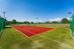 a tennis court with a net on a field at Holiday home Relax in Posedarje