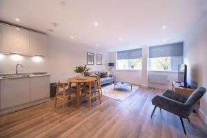 a kitchen and living room with a table and chairs at Fabulous 2BR Apartment at Trinity Point Gravesend in Gravesend