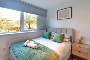 Un dormitorio con una cama con dos almohadas y una ventana. en Fabulous 2BR Apartment at Trinity Point Gravesend, en Gravesend