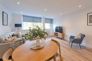 a living room with a table and a couch at Fabulous 2BR Apartment at Trinity Point Gravesend in Gravesend