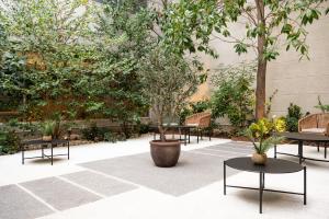 a courtyard with tables and chairs and trees at VP SOGNIO Metropolitano in Madrid