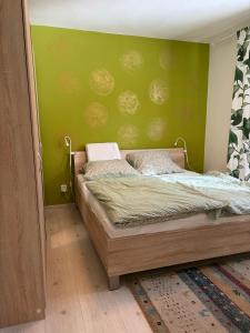 a bedroom with a bed with a green wall at Villa appartment in Vinohrady