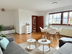 a living room with a couch and a table and chairs at NEU! Auszeit am Hirzenkopf in Steinberg-Deckenhardt