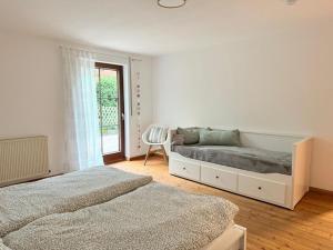 a white bedroom with two beds and a chair at NEU! Auszeit am Hirzenkopf in Steinberg-Deckenhardt