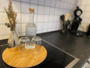 a wooden tray with three wine glasses and a bottle at NEU! Auszeit am Hirzenkopf in Steinberg-Deckenhardt +11 photos