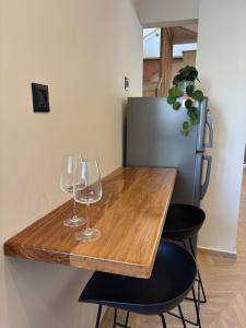 a table with two wine glasses and a refrigerator at RASHI6 Boutique Villa in Netanya