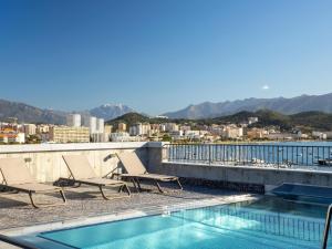 a pair of chairs and a swimming pool on a roof at ibis Styles Ajaccio Napoleon in Ajaccio