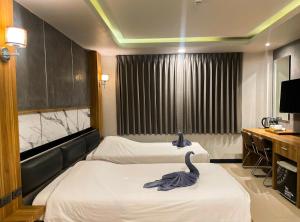 a room with two beds and a swan on the bed at The Mantra Hotel Kata Noi in Kata Beach +38 photos