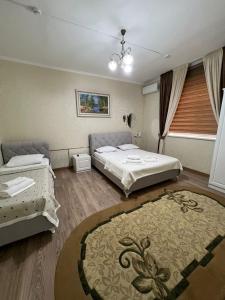 a bedroom with two beds and a rug at Keruen in Taraz +14 photos