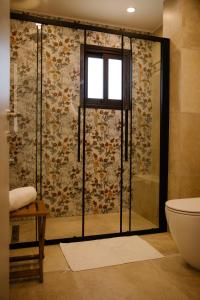 Un baño con ducha, inodoro y ventana. en Nadine sea side villas, en Lárnaca