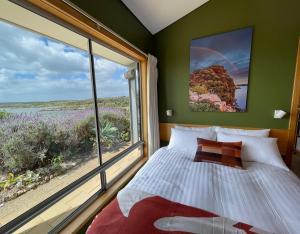 a bedroom with a bed and a large window at Moonrise Cove in Pelican Lagoon