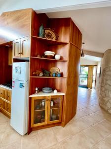 a kitchen with wooden cabinets and a white refrigerator at Moonrise Cove in Pelican Lagoon