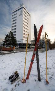 un grupo de esquís y postes de esquí en la nieve en Hotel reSTART Superior, en Jičín