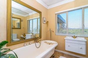 a bathroom with a tub and a large mirror at Kennedys Beach Villa in Hermanus +136 photos