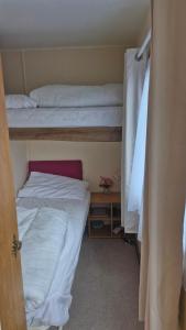 a room with two bunk beds and a door open at Static Caravan situated at Wigbay, Stranraer in Stranraer