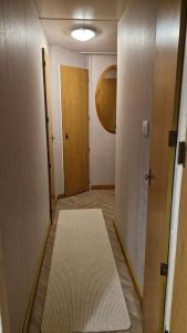 an empty hallway with a door and a rug at Static Caravan situated at Wigbay, Stranraer in Stranraer