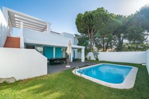 ein Hinterhof mit einem Swimmingpool und einem Haus in der Unterkunft Villa Prainha in Alvor