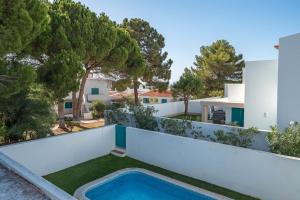 einen Blick auf den Hinterhof eines Hauses mit Pool in der Unterkunft Villa Prainha in Alvor