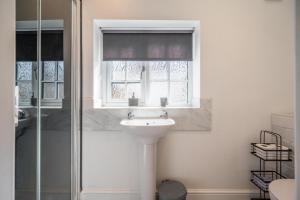 a bathroom with a sink and a window at Greenacres, Kelsale in Kelsale +30 photos