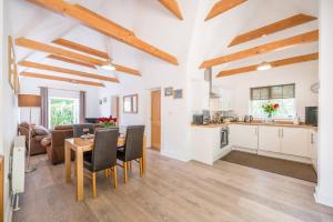 a kitchen and living room with a table and chairs at Greenacres, Kelsale in Kelsale