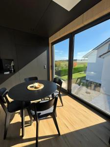 a dining room with a table and chairs and a large window at Chalet Seewald - Tiny House in Seewald