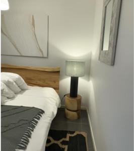 a bedroom with a bed and a lamp on a table at Villa Le Grand Bleu in Le Moule