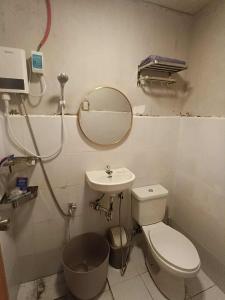 a bathroom with a toilet and a sink and a mirror at Tsinoy Villa in Pandi